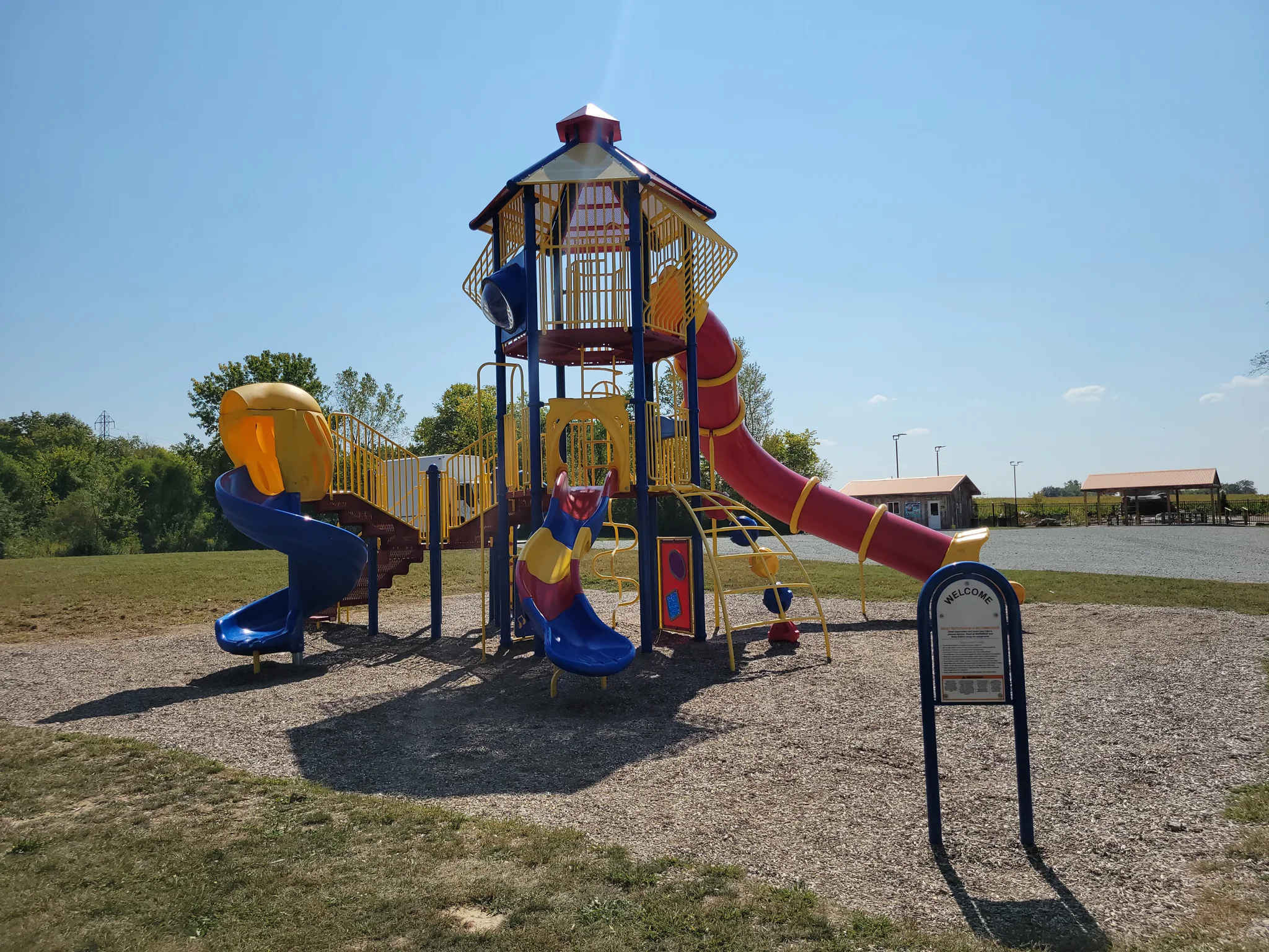 Colorful playground with slides and climbing structure on a sunny day.