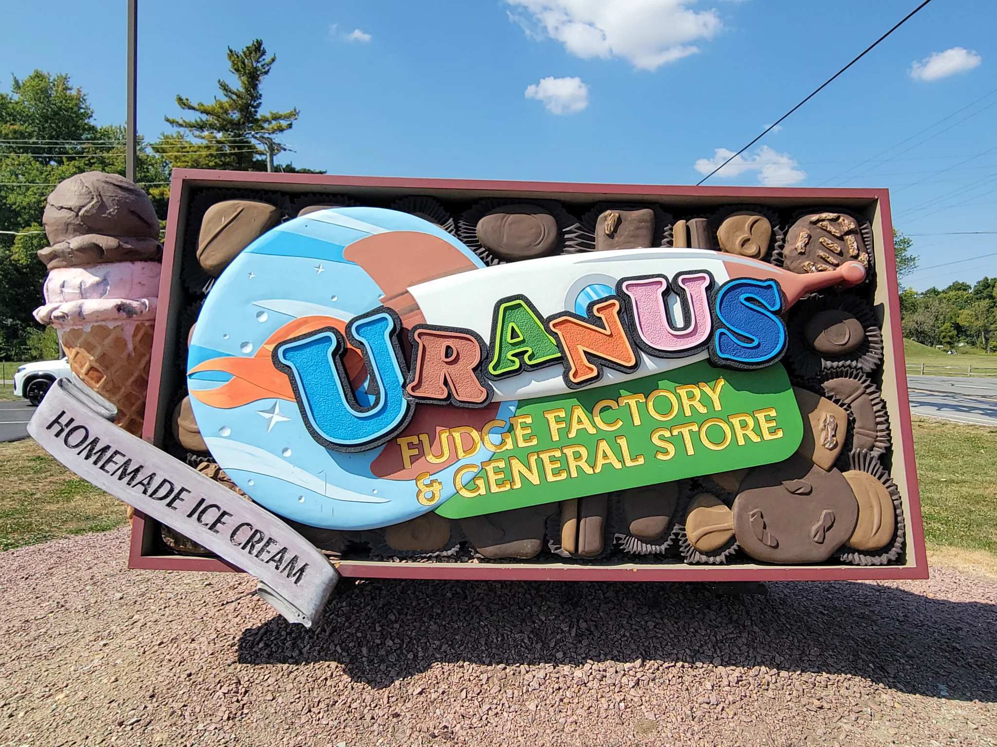 Sign for Uranus Fudge Factory and General Store with ice cream graphic.