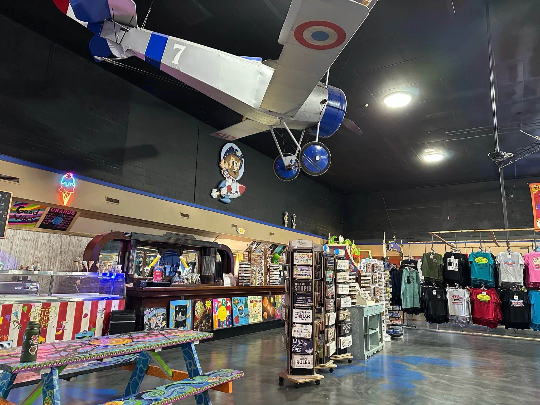 Store interior with vintage airplane model and merchandise displays.