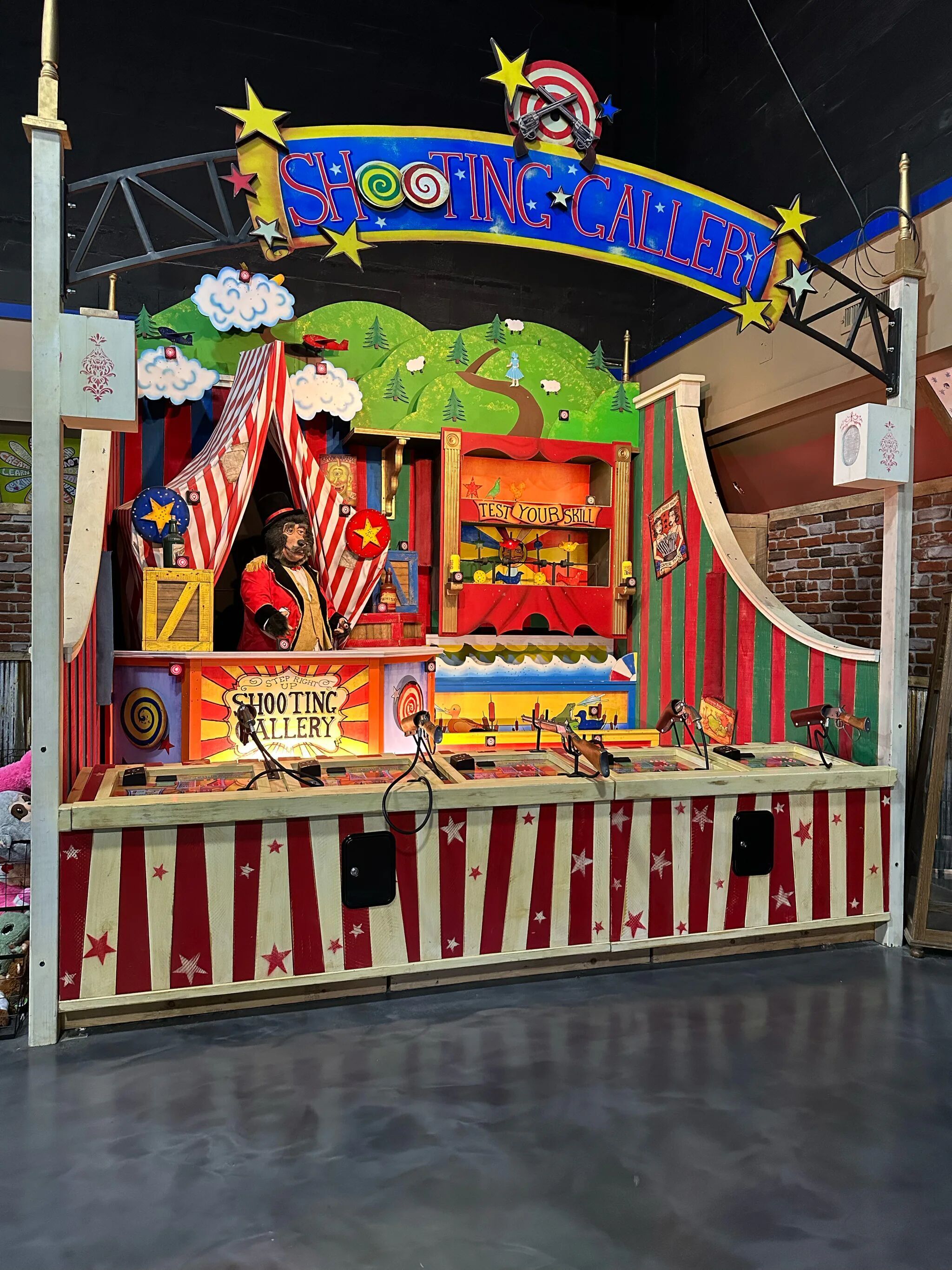 Shooting gallery game booth with colorful decorations and targets.